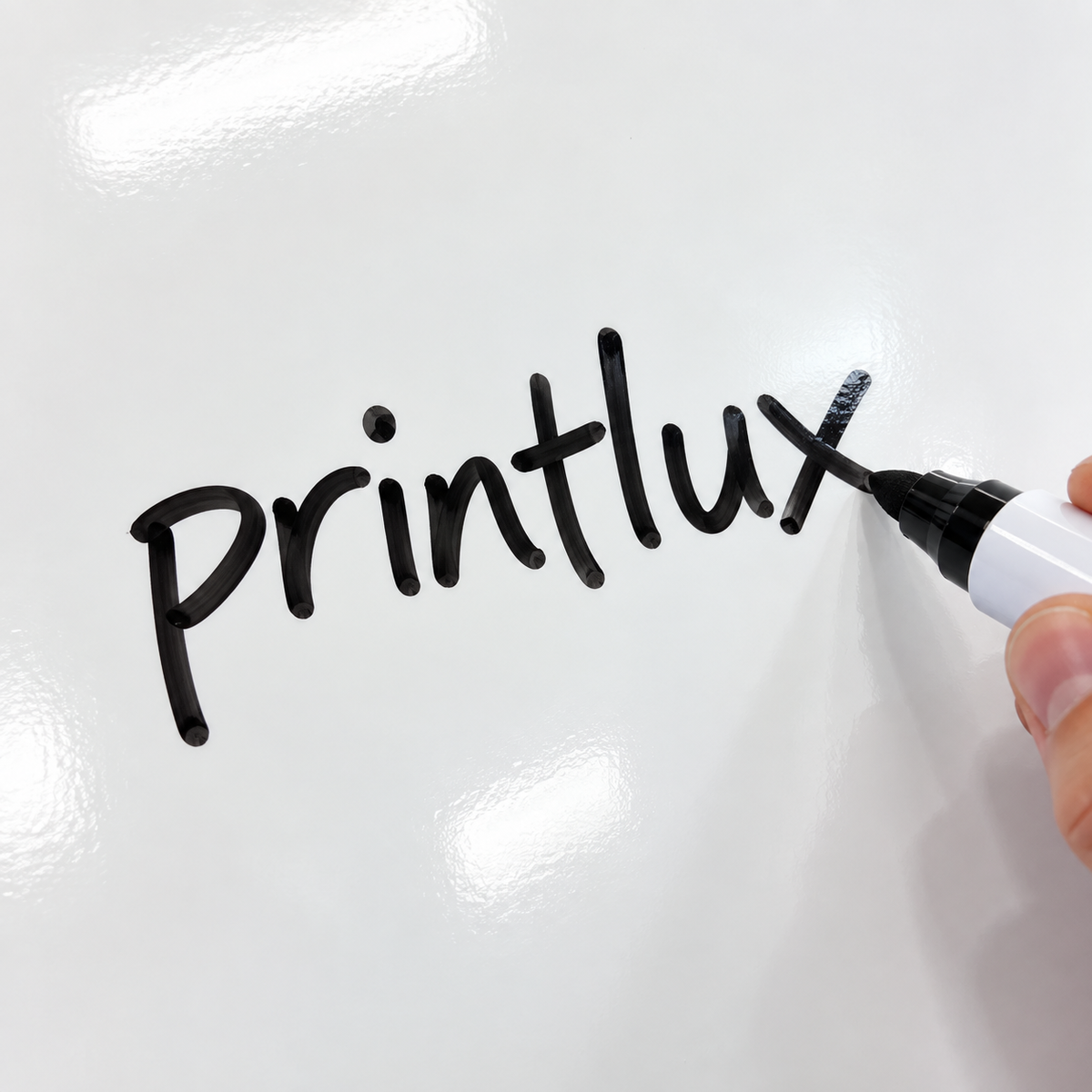 A hand is writing the word "Printlux" on a white surface using a black marker.
