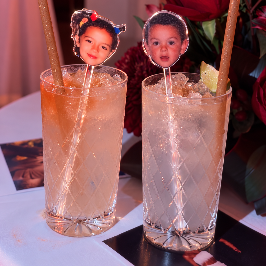 Clear personalised childhood photo drinks stirrers displayed in two cocktail glasses