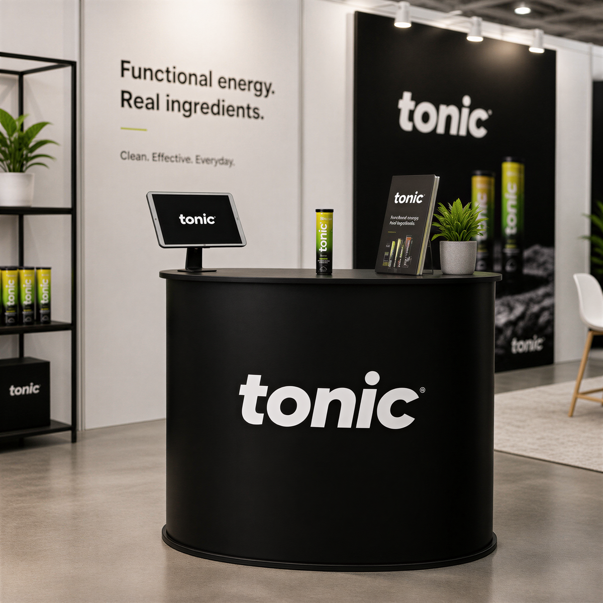 a promotional display for a company called "tonic". The display includes a black circular counter with the company's logo, a sign, and various products such as bottles and a plant. The background of the image includes a wall with text and a logo, suggesting that the display is part of a larger exhibition or event.