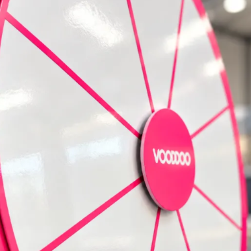 A close-up of a large, bright pink spinning wheel with the word "VOOVO" written on it.