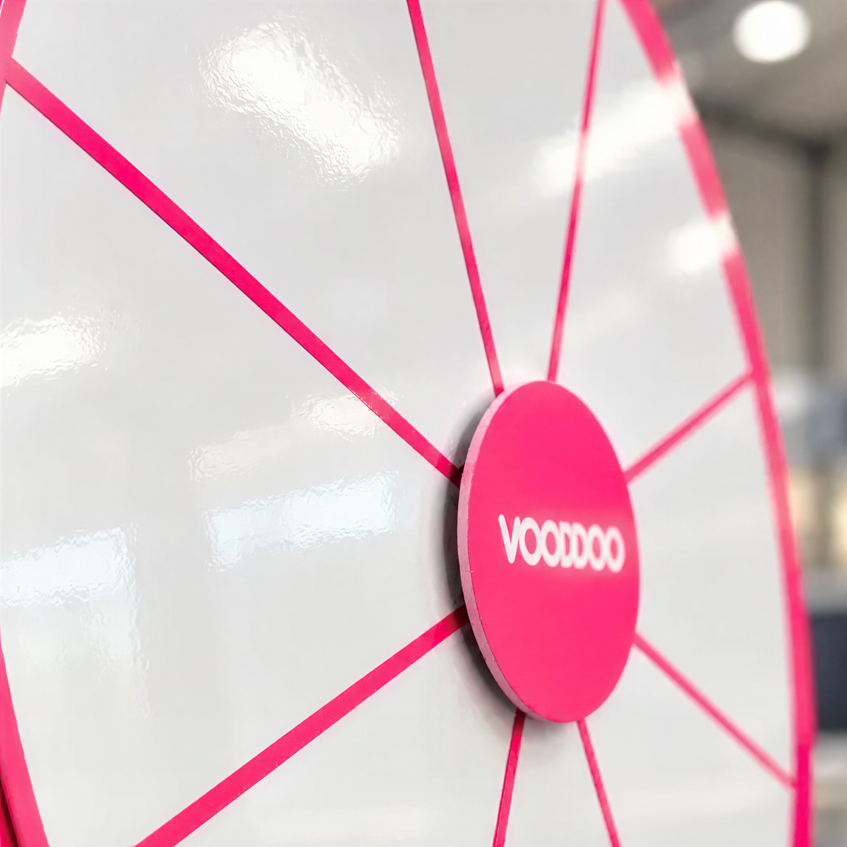 A close-up of a large, bright pink spinning wheel with the word "VOOVO" written on it.