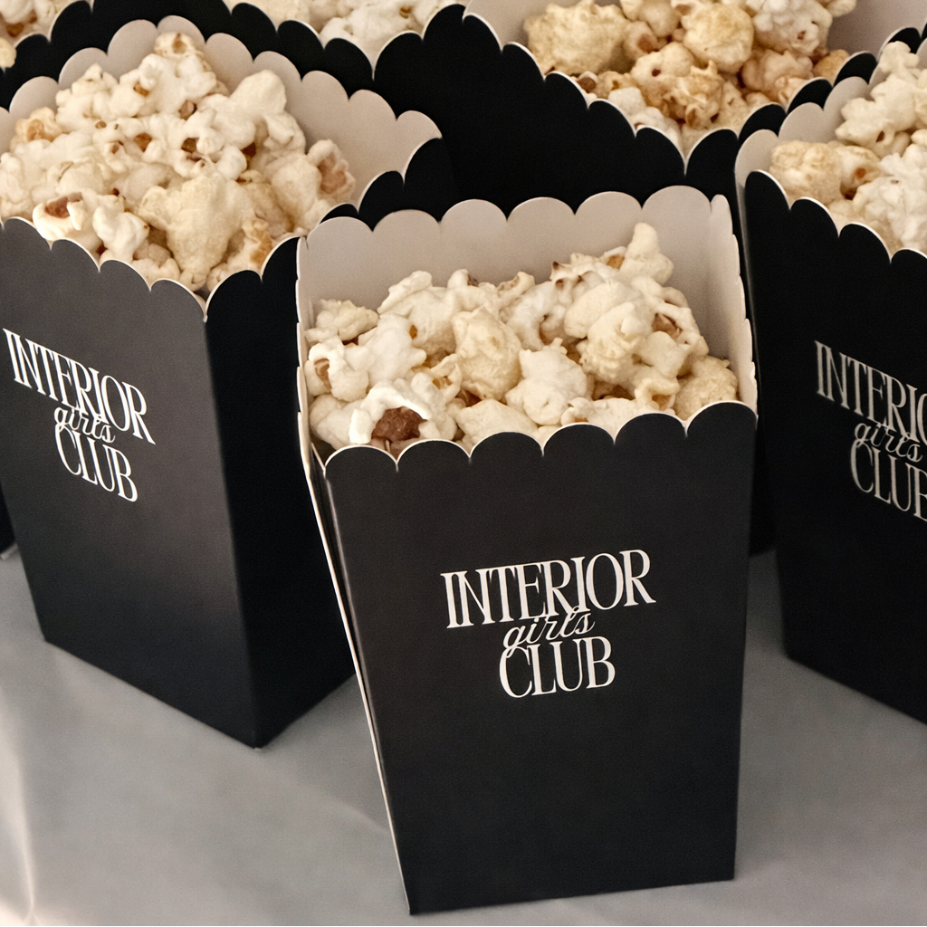 several black popcorn boxes filled with popcorn, arranged on a table.