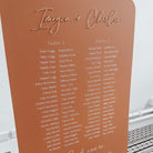 A collection of colorful name cards or place cards, each with a different color and text, placed on a white plate or napkin. The cards are arranged in a row, and there are flowers visible in the background.