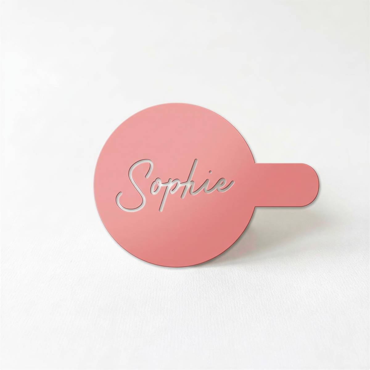 A pink circular object with the name "Sophie" written on it.