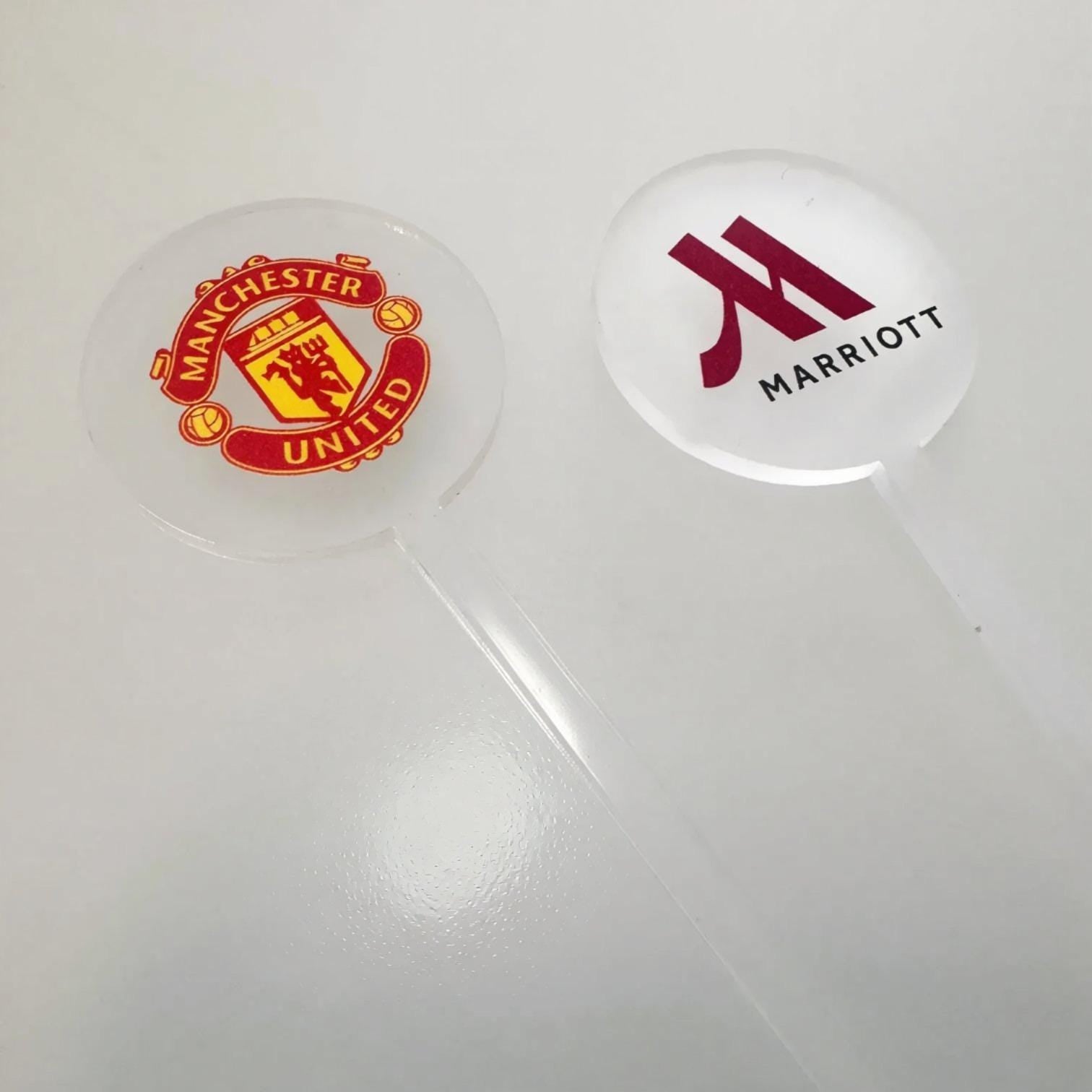 two circular objects, one with the logo of Manchester United football club and the other with the logo of Marriott hotel.