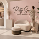 A woman is standing in a modern, minimalist-style room with a pink wall, a white sofa, and a potted plant.