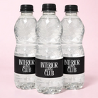 Three identical clear plastic bottles with black caps and labels that say "INTERIOR girls CLUB" are arranged in a row against a pink background.