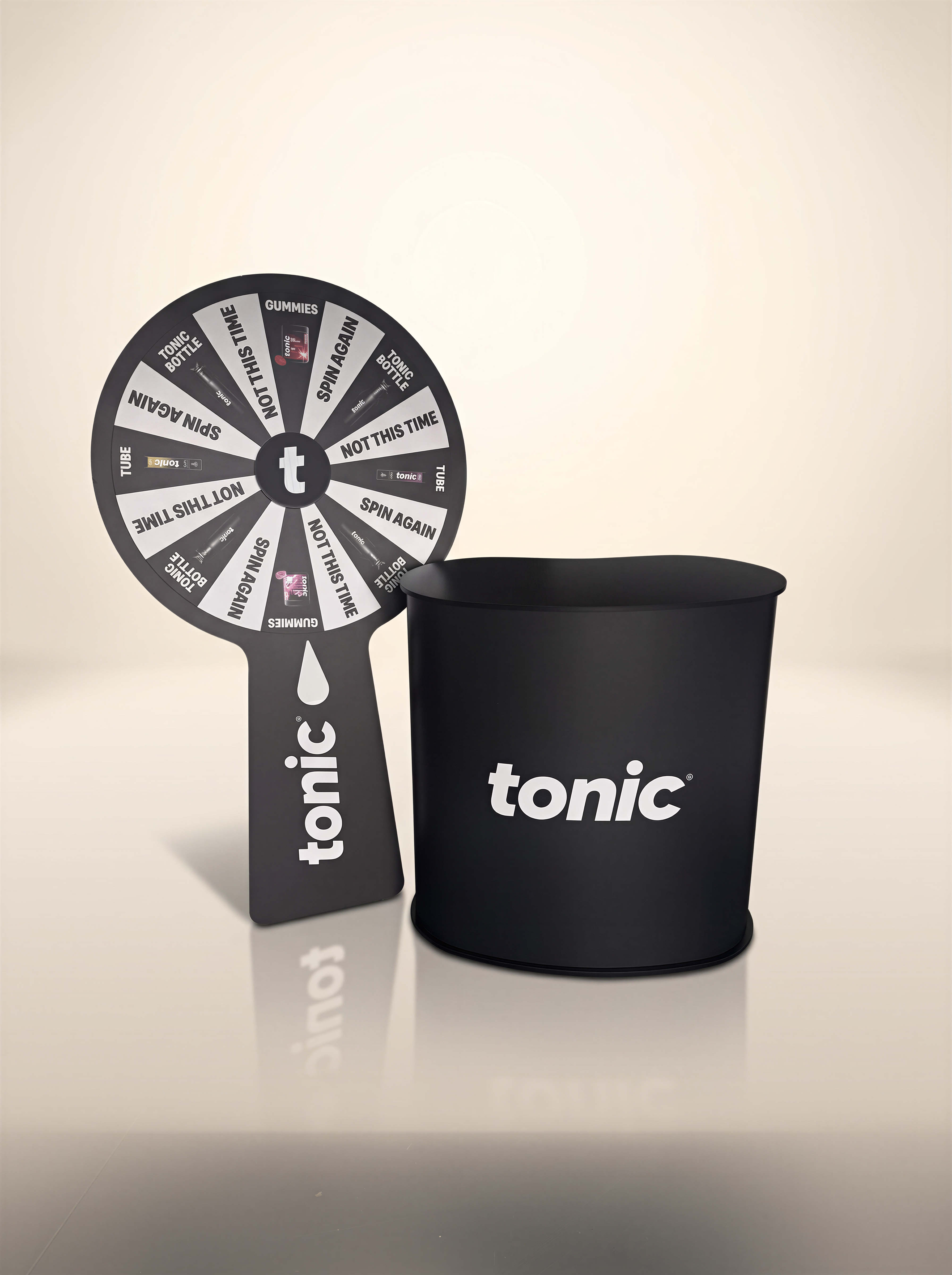 a black spin wheel and a black container with the word "tonic" written on it, both placed on a white surface.