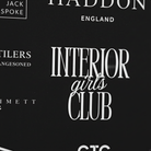 a close-up view of a black background with white text and logos. The text and logos appear to be related to a club or organization, but the exact content is not clear due to the close-up nature of the image.