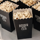 several black popcorn boxes filled with popcorn, arranged on a table.